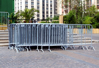 An iron temporary mobile fence stands in a pile.