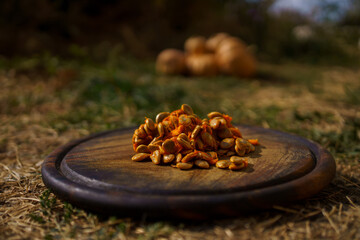 Raw pumpkin seeds on a wooden background, pear-shaped pumpkins lie nearby, autumn harvest