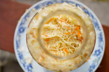Homemade sauerkraut in a glass jar is a healthy food. Lactic acid fermentation, ripening of grated white cabbage, vegetarian cabbage salad in a jar, close-up