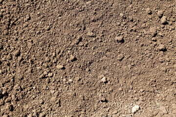 Texture of plowed smoothed brown soil.