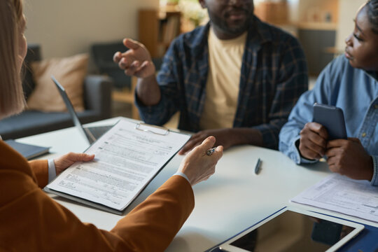 Close up of woman holding clipboard consulting family in therapy session or insurance agency copy space