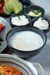 Bowl of oatmeal served on breakfast buffet with fruit and dairy