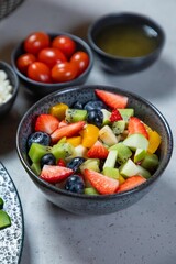 Making a fresh fruit salad with strawberries, apples and blueberries