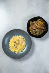 Saffron rice with herbs accompanying eggplant stew on table