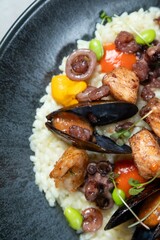 Delicious seafood risotto with mussels and octopus being served on a plate