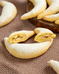 Freshly baked crescent shaped cookies showing filling on brown cloth