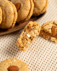 Freshly baked almond cookies resting on a wooden plate