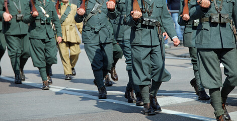 soldiers in old uniforms from the First World War and historical rifles in hand during the...