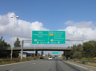 road sign on the highway in Denmark shows directions to multiple locations and gives clear driving...