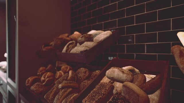 Various types of bread displayed in baskets on store shelves.