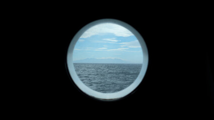 View from round deck window to sea. Clip. Beautiful seascape with mountain coast on horizon from...