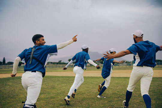 Excited baseball team celebrating as winners on the field after league victory