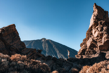 Woman standing between rocky formations with a Teide mountain background