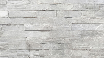 Close-up texture of a gray stacked stone wall for architectural design, construction, and home improvement.