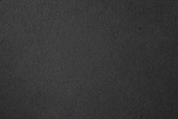 Close-up of dark textured black paper surface, ideal for backgrounds, textures, and minimalist design projects.