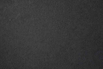 Close-up of dark textured black paper surface, ideal for backgrounds, textures, and minimalist design projects.
