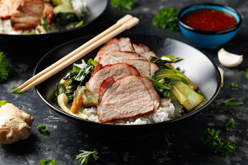 Chinese BBQ Pork Char Siu with rice and bok choy in a black bowl