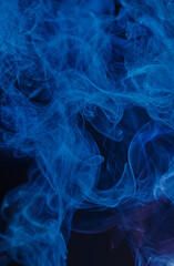 Abstract swirls of blue smoke against a dark background, creating a mysterious and fluid pattern.