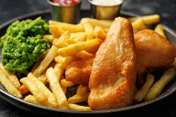 British Fish and chips with mashed peas, tartar and ketchup sauce.