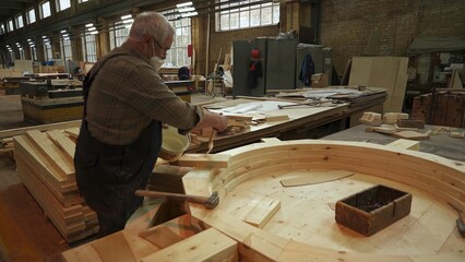 A skilled craftsman works in a woodworking shop, creating stunning pieces of art. Stock Clip