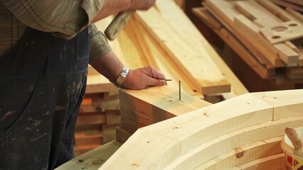 A skilled craftsman diligently working with wood in his well equipped workshop space. Stock Clip