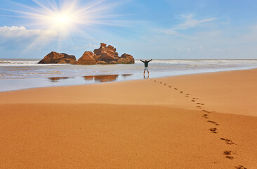 A young tourist walks along the ocena coast enjoying the views, Morocco