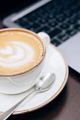 A laptop and a cup of coffee on the table. Office workday