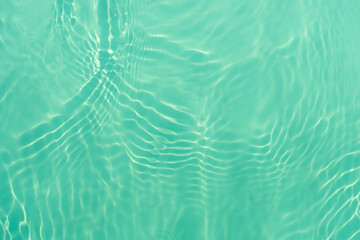 Blue water with ripples on the surface. Defocus blurred transparent blue colored clear calm water surface texture with splashes and bubbles. Water waves with shining pattern texture background.