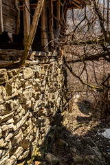 Abandoned houses and other buildings, lit by sunlight, street view, Pirin village and mountain, Bulgaria