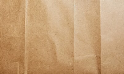 Fototapeta premium Textured brown kraft paper with folds and creases. Concept of packaging and natural materials.