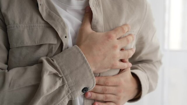 Heart problems.
Heart attack.
Pain in the heart.
A man holds his chest with his hands and suffers from severe pain