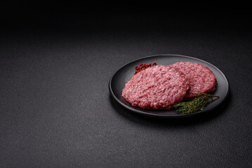 Fresh raw ground beef burger patty with salt and spices