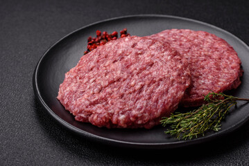 Fresh raw ground beef burger patty with salt and spices