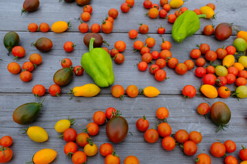 Ripe tomatoes and peppers on a wooden table, upper view. Vegetable background for publication, poster, screensaver, wallpaper, banner, cover, post. Food concept. Healthy diet. High quality photo
