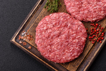Fresh raw ground beef burger patty with salt and spices