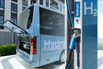 Hydrogen gas station and bus with an open hood and a hydrogen cylinder inside. Clean mobility...