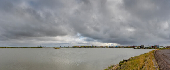 Distant panoramic view of Tuktoyaktuk from across the Arctic Ocean in the Northwest Territories, Canada