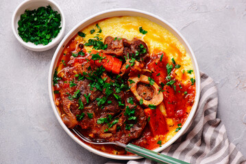 Stewed in osso bucco sauce with vegetables and cheese polenta in a bowl.style huggr