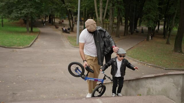 Father and son are riding bicycles in park. Family time concept.