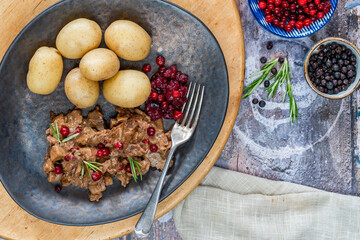 Traditional Norwegian reindeer stew with lingonberries and boiled potatoes