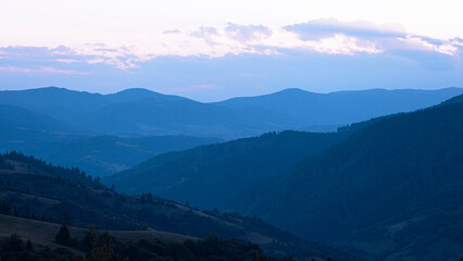 Fototapeta premium Blue sunset with the setting sun behind the mountains