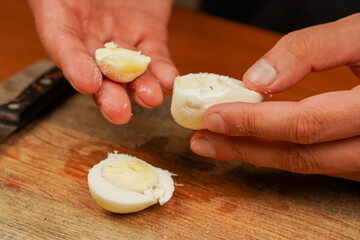 Healthy food. Board with boiled chicken eggs on table, closeup. Protein. Sportsmen's food. Preparing food. Horizontal photo. Vegetarian. Man holding chicken eggs over wooden board. Boiled eggs.