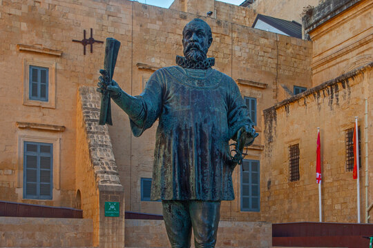 Valletta, Malta - February 13, 2024: Bronze statue of Grand Master Jean Parisot  de Vallette, in Pjazza Jean de Vallette, with Our Lady of Victories Chapel behind,