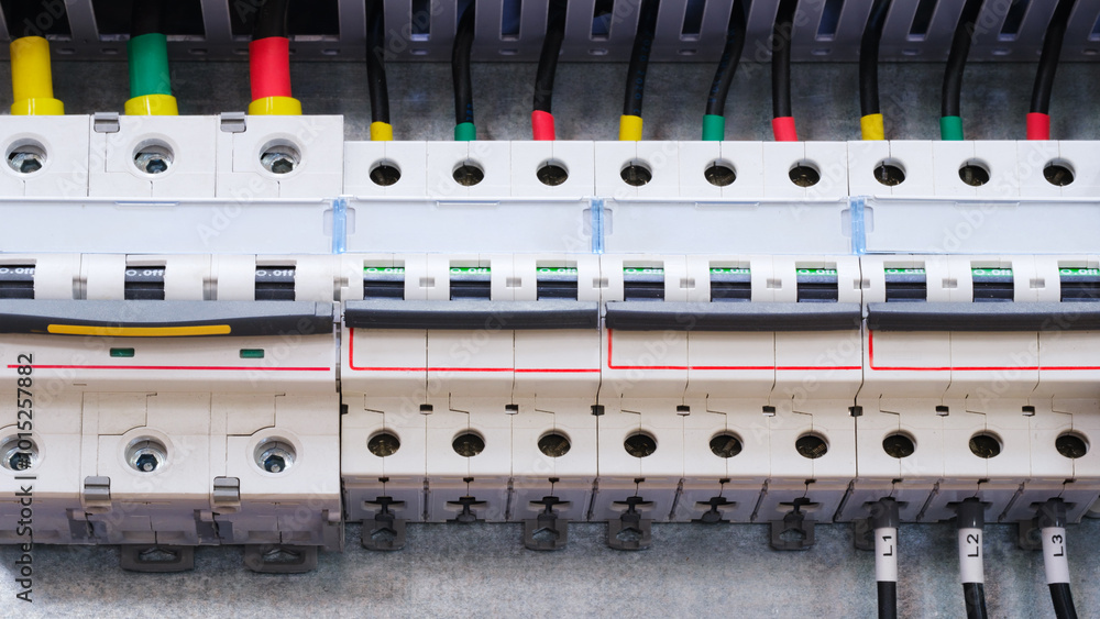 Poster A close up of a power box with many wires and outlets. The box is white and has a red stripe