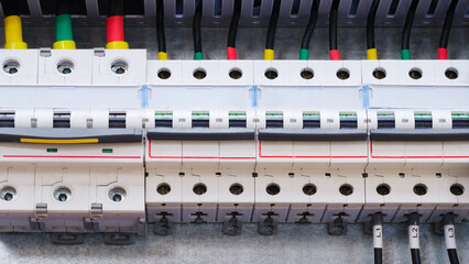 A close up of a power box with many wires and outlets. The box is white and has a red stripe