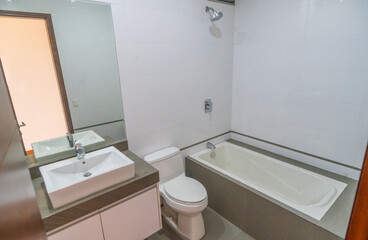 baño de departamento iluminado con lavabo , inodoro y  tina para baño