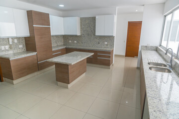 cocina moderna con acabados de marmol, muebleas altos y bajos y equipado