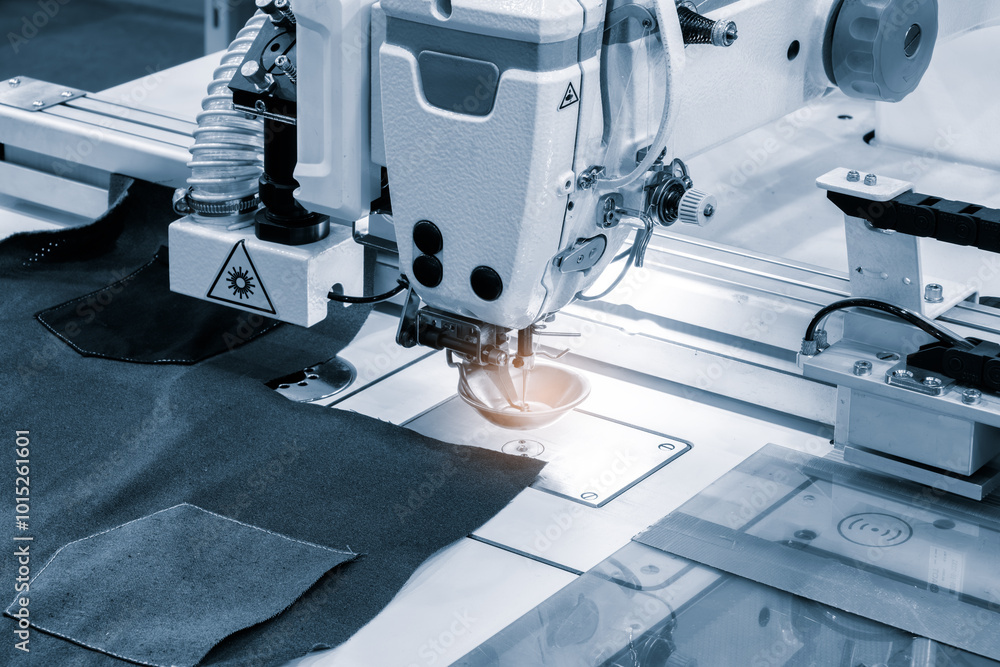 Poster a sewing machine is in use, with a piece of fabric being sewn. the machine is blue and white, and th