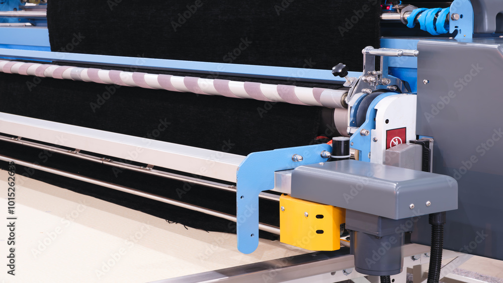 Poster a machine is shown with a black fabric on it. the machine is blue and silver. the machine is used to