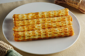 Crispy homemade waffles served on a round platter set against a neutral table setting in soft afternoon light